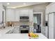 Bright kitchen boasts white cabinetry, stainless steel appliances, and a contrasting dark wood floor at 5752 S Jasmine St, Greenwood Village, CO 80111