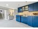 Cozy kitchenette featuring dark blue cabinetry and granite counters next to a stairway at 5752 S Jasmine St, Greenwood Village, CO 80111
