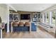 Modern living room with a wood accent wall, built-in shelves, and a dining area with bar seating at 5752 S Jasmine St, Greenwood Village, CO 80111