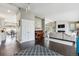 Open-concept living room with a white brick fireplace, dark wood floors, and access to the dining area at 5752 S Jasmine St, Greenwood Village, CO 80111