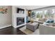 Comfortable living area featuring a stone fireplace, large windows, and hardwood flooring at 5752 S Jasmine St, Greenwood Village, CO 80111