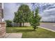 View of the spacious front yard featuring lush green grass and mature trees, enhancing the curb appeal of the property at 19688 E Lasalle Dr, Aurora, CO 80013