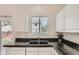 Bright kitchen featuring black tile countertops, a window above the sink, and white cabinetry at 19688 E Lasalle Dr, Aurora, CO 80013