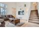 Bright living room with tall ceilings, a brown leather sofa, and a decorative rug at 19688 E Lasalle Dr, Aurora, CO 80013