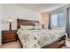 Bedroom featuring a large bed with floral bedding, two side tables, and natural light at 19688 E Lasalle Dr, Aurora, CO 80013