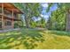 Lush green backyard with a stone patio and balcony overlooking the yard at 1 Lindenwood Dr, Littleton, CO 80120