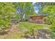 Expansive backyard featuring lush lawn, stone patio with mature trees, perfect for outdoor enjoyment and privacy at 1 Lindenwood Dr, Littleton, CO 80120