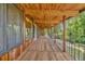 Long balcony with wood floors, exposed beams, and views of green trees at 1 Lindenwood Dr, Littleton, CO 80120