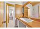 Bathroom featuring a wood countertop, a large sink, and a view to another bathroom at 1 Lindenwood Dr, Littleton, CO 80120