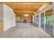 Open living room with exposed wood ceiling beams, a cozy brick fireplace, and access to an outdoor deck at 1 Lindenwood Dr, Littleton, CO 80120