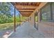 Brick covered patio with exposed wooden beams and concrete floor at 1 Lindenwood Dr, Littleton, CO 80120