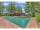 Outdoor pool with brick surround, adjacent building and mature trees at 1 Lindenwood Dr, Littleton, CO 80120