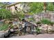 Secluded backyard featuring a tranquil rock garden, a calming pond with a waterfall, and lush greenery at 8029 E 23Rd Ave, Denver, CO 80238