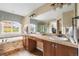 Bright bathroom featuring double sinks, soaking tub, walk-in shower, and a large mirror for a luxurious experience at 8029 E 23Rd Ave, Denver, CO 80238