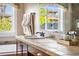 Comfortable bathroom with elegant vanity, tile countertop, and natural light streaming in through a large window at 8029 E 23Rd Ave, Denver, CO 80238