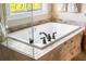Elegant bathroom showcasing a bathtub with tile surround, natural light, and modern fixtures at 8029 E 23Rd Ave, Denver, CO 80238
