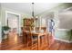 Traditional dining room boasts hardwood floors, wooden table, and hutch with charming chandelier at 8029 E 23Rd Ave, Denver, CO 80238