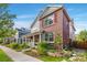 Attractive two-story home featuring a brick facade, covered porch, and well-maintained landscaping at 8029 E 23Rd Ave, Denver, CO 80238
