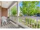 Cozy front porch with classic white columns, a striped rug, and a serene view of the tree-lined street at 8029 E 23Rd Ave, Denver, CO 80238