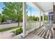 Relaxing front porch featuring white columns, a striped rug, and a view of the peaceful neighborhood at 8029 E 23Rd Ave, Denver, CO 80238