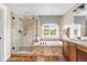 Luxurious bathroom featuring a shower, bathtub, double vanity, and large window at 8029 E 23Rd Ave, Denver, CO 80238