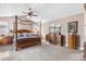 Spacious main bedroom featuring a four-poster bed, ceiling fan, and dresser with mirror at 8029 E 23Rd Ave, Denver, CO 80238