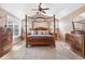 Bright main bedroom featuring a four-poster bed, ceiling fan, and dresser with mirror at 8029 E 23Rd Ave, Denver, CO 80238
