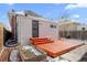 Cozy backyard with a wooden deck and a house with white siding and red trim at 2919 N York St, Denver, CO 80205