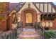 Close-up of the arched front door with brick surround and stone steps with wrought iron railings at 1930 E 8Th Ave, Denver, CO 80206