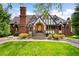 Charming Tudor home boasts a red brick facade, manicured lawn, and a unique chimney design at 1930 E 8Th Ave, Denver, CO 80206