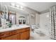Bathroom featuring white tile, a vanity with wood cabinets, and a shower-tub combination at 203 Wright St # 102, Lakewood, CO 80228