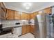 Bright kitchen equipped with stainless steel appliances, granite countertops, and ample oak cabinet storage at 203 Wright St # 102, Lakewood, CO 80228