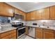 A well-equipped kitchen showcasing stainless steel appliances, granite countertops and oak cabinetry at 203 Wright St # 102, Lakewood, CO 80228