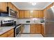 Well-lit kitchen featuring stainless steel appliances and oak cabinetry, complete with granite countertops at 203 Wright St # 102, Lakewood, CO 80228