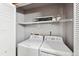 Convenient laundry room equipped with a washer, dryer, and shelving for easy organization and storage at 203 Wright St # 102, Lakewood, CO 80228