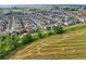 A neighborhood aerial view showcases the community's layout with fields and hay bales in background at 17765 Faraday St, Broomfield, CO 80023