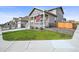 A home featuring a quaint front porch, well-manicured lawn, and an attached two-car garage at 17765 Faraday St, Broomfield, CO 80023