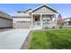 Charming home featuring a quaint front porch, well-manicured lawn, and an attached two-car garage at 17765 Faraday St, Broomfield, CO 80023