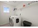 Convenient laundry room equipped with a washer, dryer, and shelving for organized storage at 17765 Faraday St, Broomfield, CO 80023