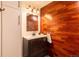 Bathroom vanity featuring modern fixtures, a wood accent wall, and combined shower/tub at 1260 York St # 204, Denver, CO 80206
