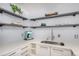 Stylish kitchen with white countertops, modern appliances, and open shelving with decor at 1260 York St # 204, Denver, CO 80206