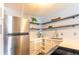 Bright kitchen featuring stainless steel appliances, sleek white cabinets, and stylish open shelving at 1260 York St # 204, Denver, CO 80206