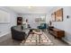 Cozy living room with a gray sectional, vibrant teal chair, modern rug, and natural light from the window at 1260 York St # 204, Denver, CO 80206