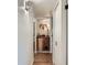 Hallway with hardwood floors, decorative lighting, and a unique cabinet at 8335 Fairmount Dr # 11-203, Denver, CO 80247