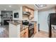 Well-maintained kitchen with tan cabinets, solid countertops, and modern appliances at 8335 Fairmount Dr # 11-203, Denver, CO 80247