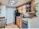 Compact kitchen featuring light wood cabinets, modern appliances, and a stainless steel sink at 8335 Fairmount Dr # 11-203, Denver, CO 80247