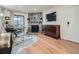 Cozy living room featuring a stone fireplace, sleek furnishings, and hardwood flooring at 8335 Fairmount Dr # 11-203, Denver, CO 80247