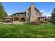 Stunning home featuring a stone chimney, manicured lawn, and an outdoor living space with pergola at 4282 Preserve N Pkwy, Greenwood Village, CO 80121