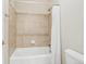 Bathtub and shower with tiled walls and white shower curtain and toilet at 8977 Crossington Way, Lone Tree, CO 80124