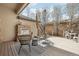 Cozy deck with outdoor fireplace, seating, and a view of blossoming trees at 8977 Crossington Way, Lone Tree, CO 80124